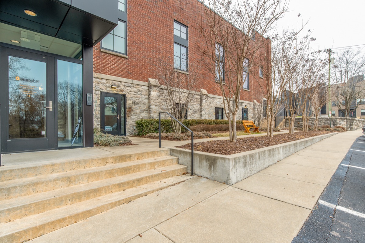 The side entrance, its glass doors set into brick above a limestone base, reached by a broad flight of steps.