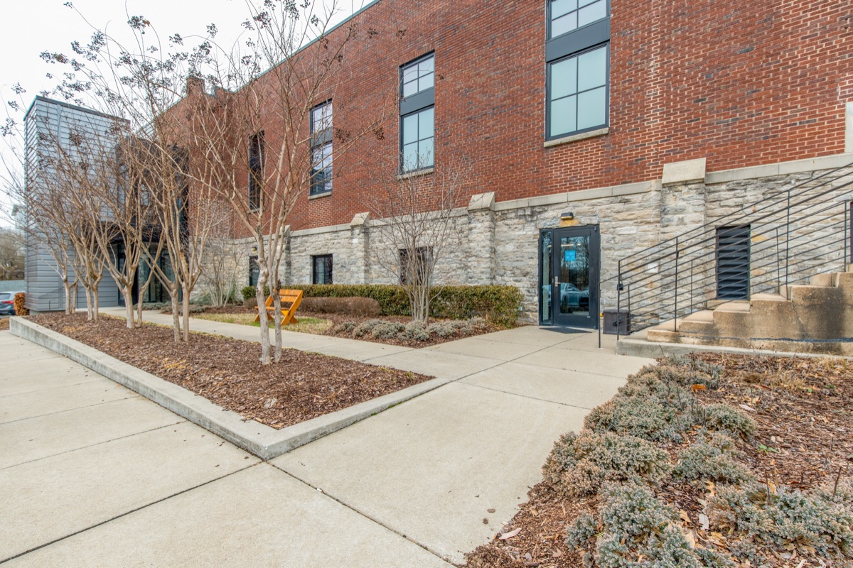 The dedicated Garden Level entrance in the limestone base of the building, with crape myrtles along the walk.